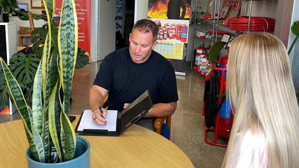 An image of a man writing on a notepad