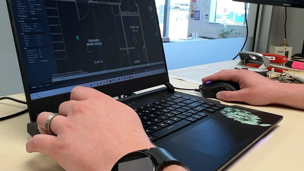 A close up of someone working on a building plan on a computer